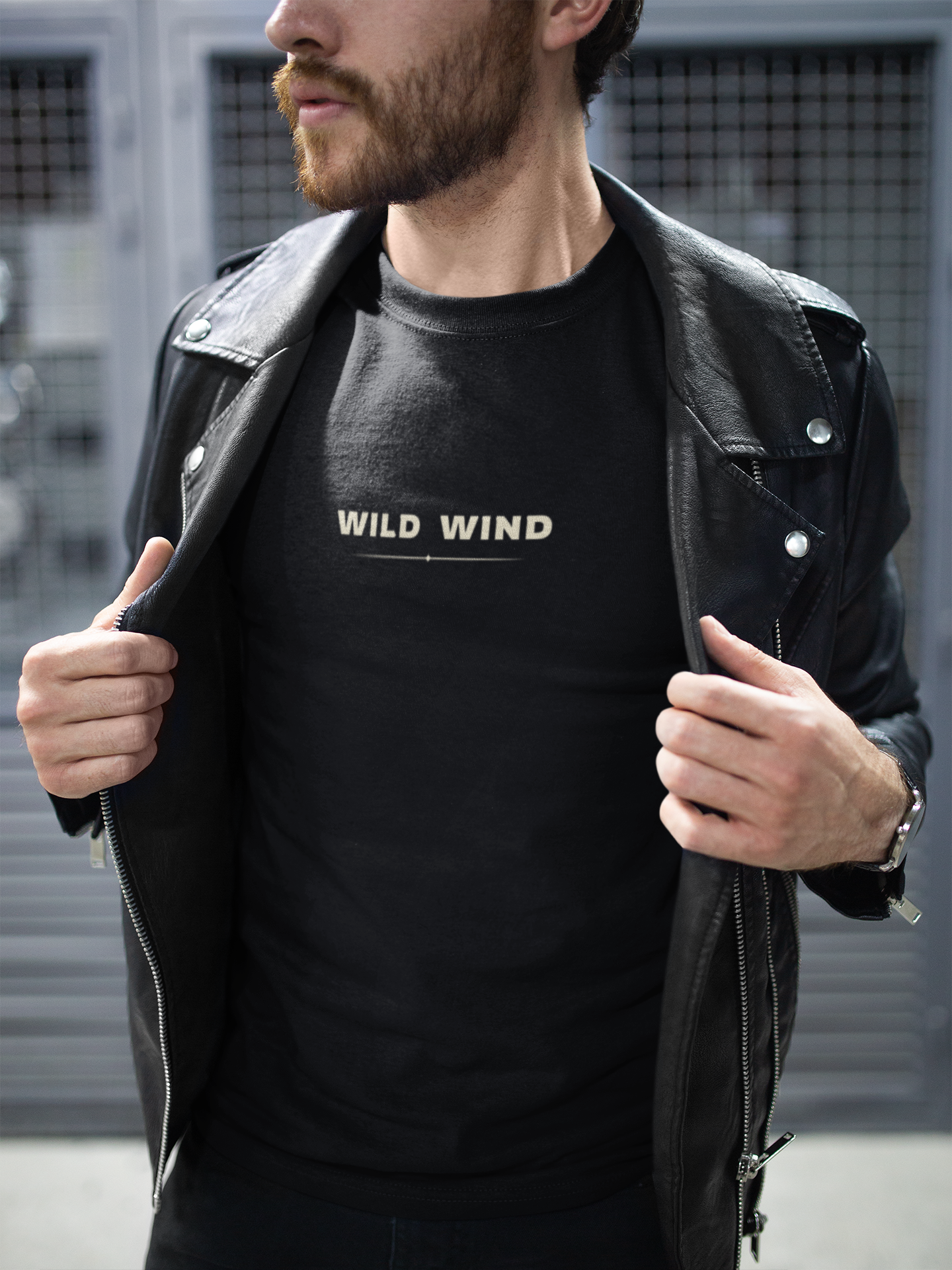 Person wearing a black t-shirt with 'WILD WIND' text, standing outdoors.