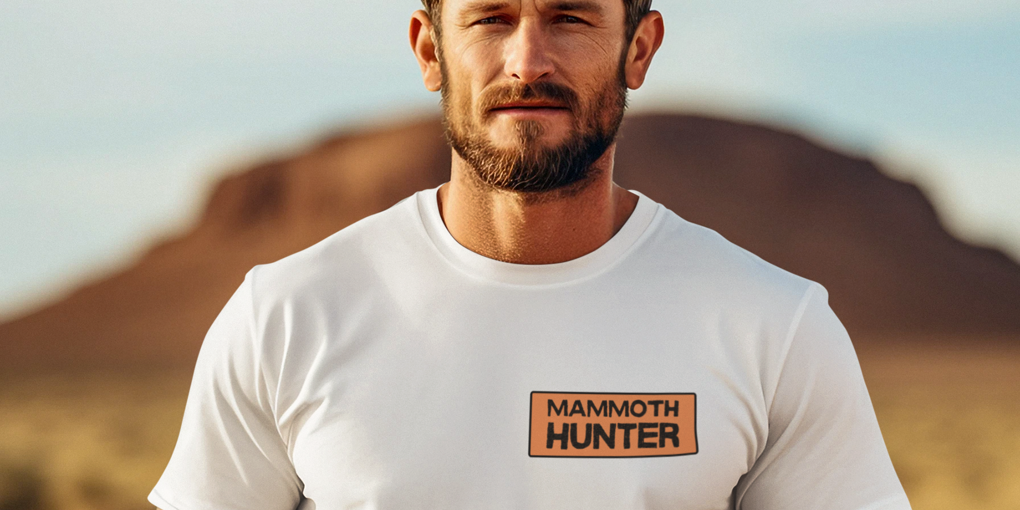 Man wearing a white t-shirt with 'Mammoth Hunter' logo in a desert setting